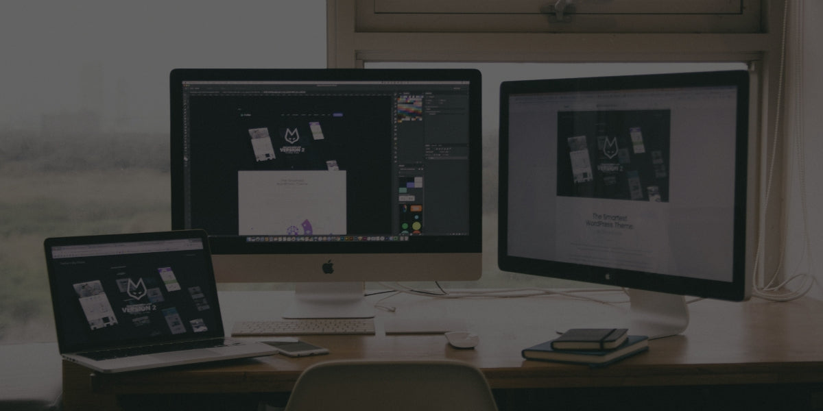 Three computer monitors on a desk with a blurred background