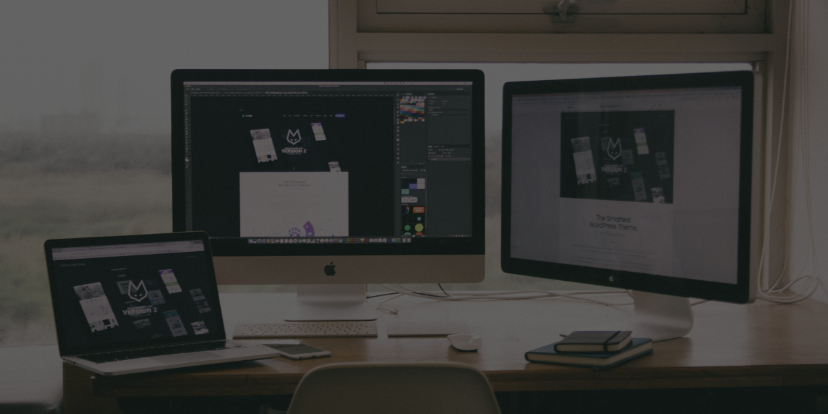 Three computer monitors on a desk with a blurred background